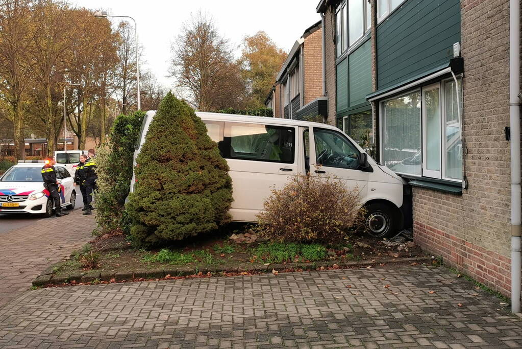 Taxibus met kinderen rijdt tegen woning