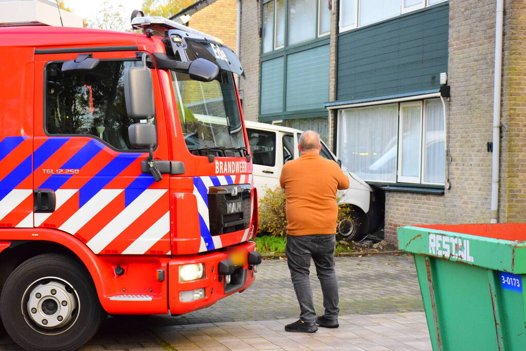 Taxibus met kinderen rijdt tegen woning