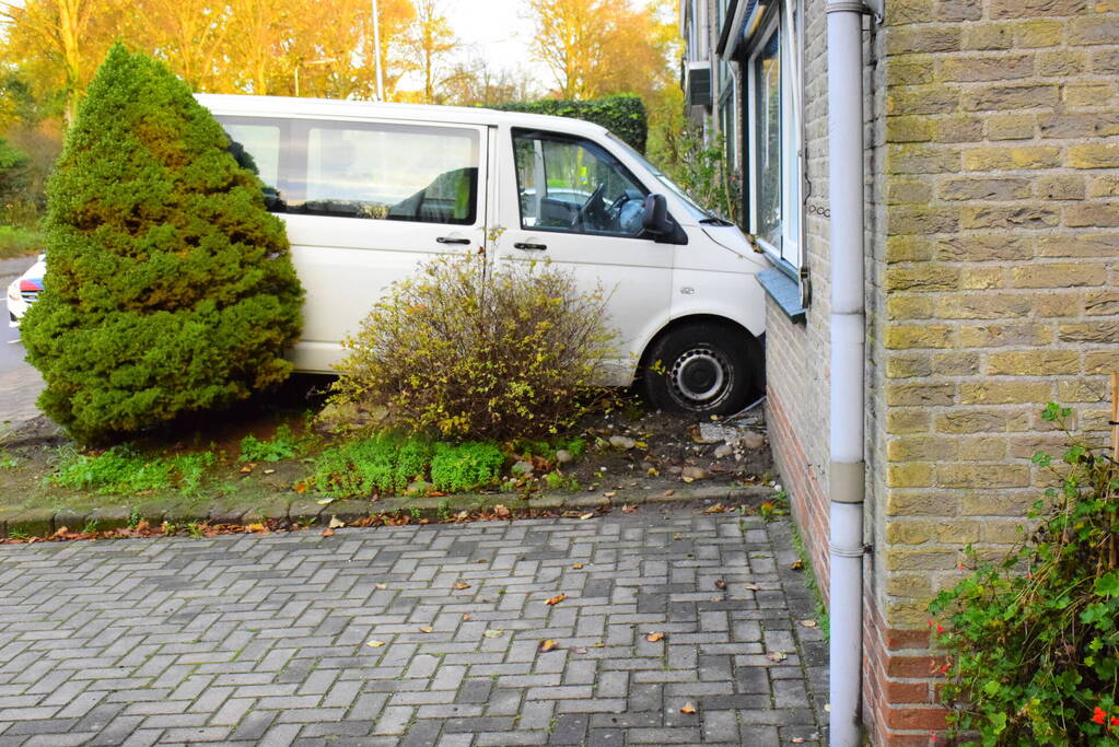 Taxibus met kinderen rijdt tegen woning