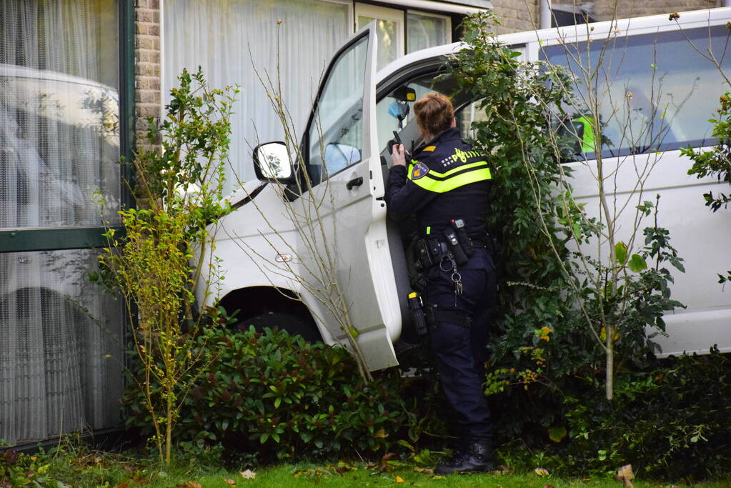Taxibus met kinderen rijdt tegen woning
