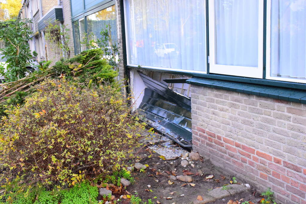 Taxibus met kinderen rijdt tegen woning