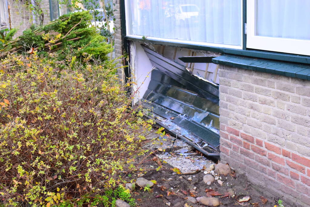 Taxibus met kinderen rijdt tegen woning