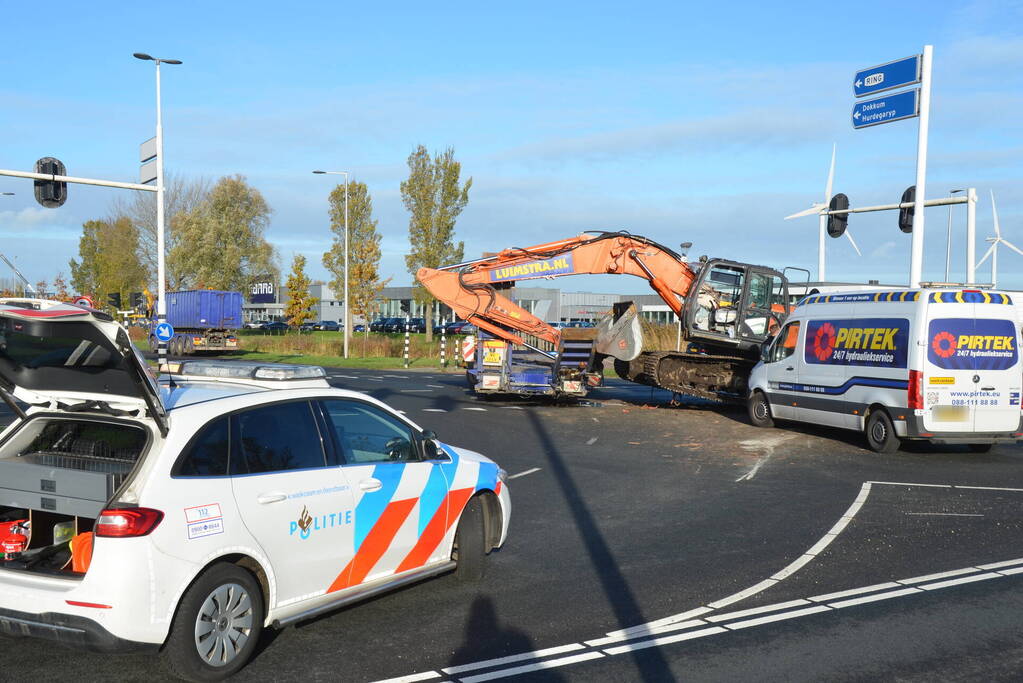 Graafmachine valt van dieplader