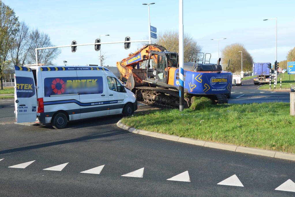 Graafmachine valt van dieplader