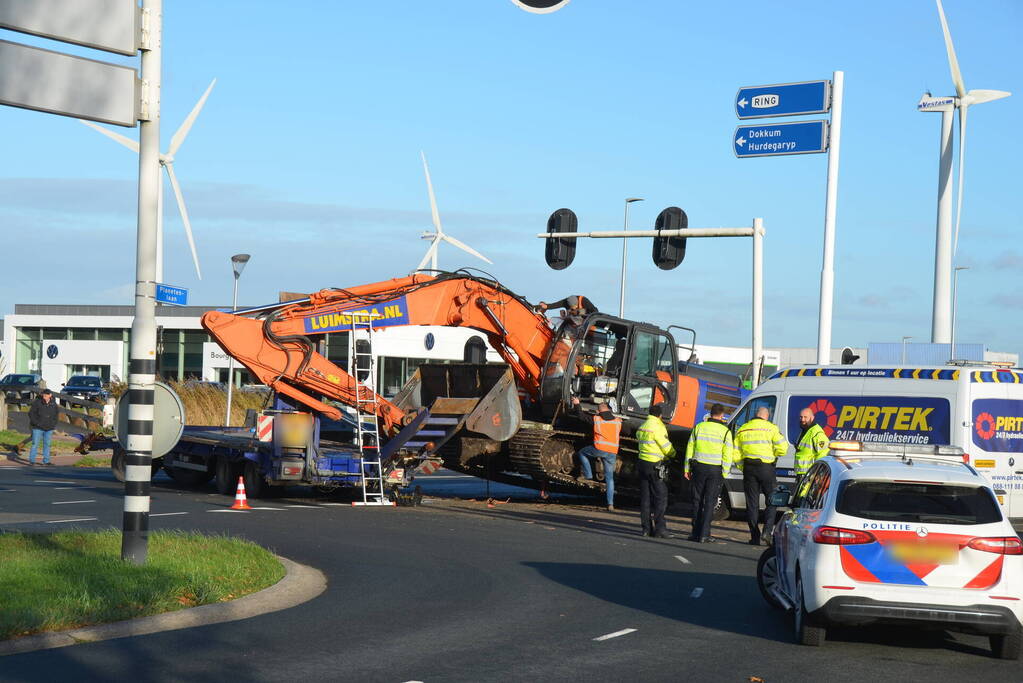 Graafmachine valt van dieplader