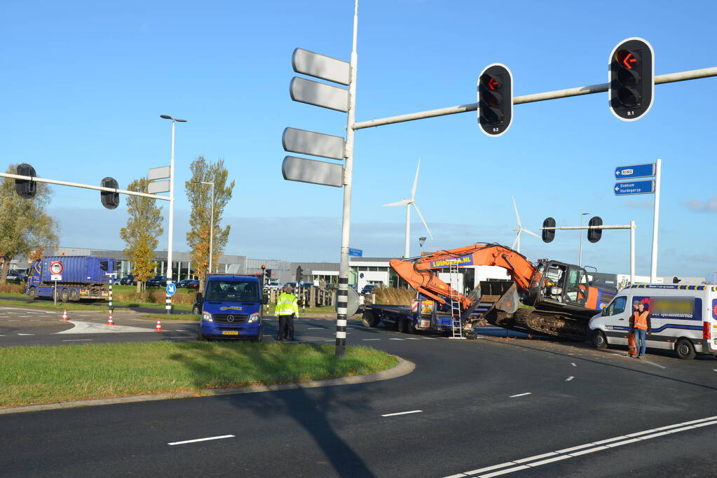 Graafmachine valt van dieplader