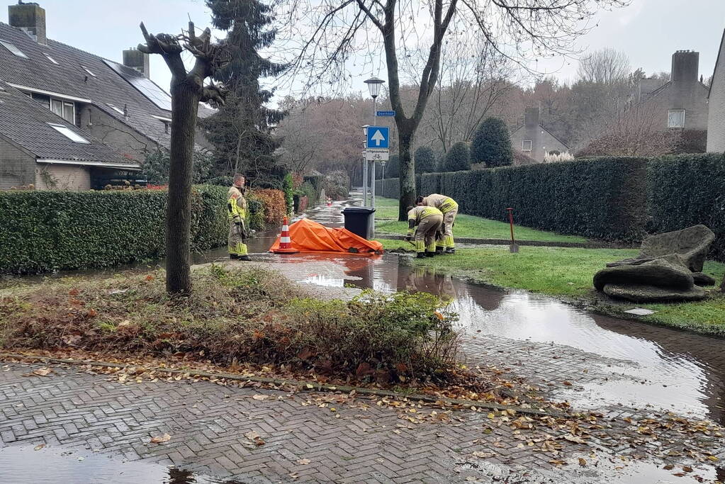Straat onderwater door gesprongen waterleiding