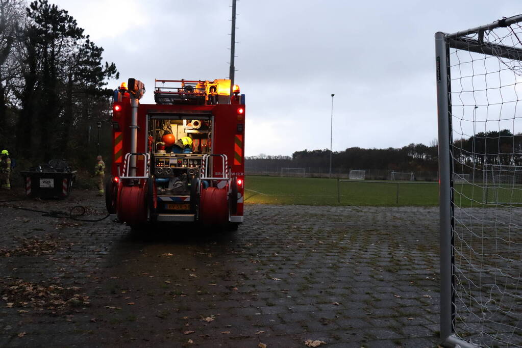 Wasmachine in brand tegen gebouw
