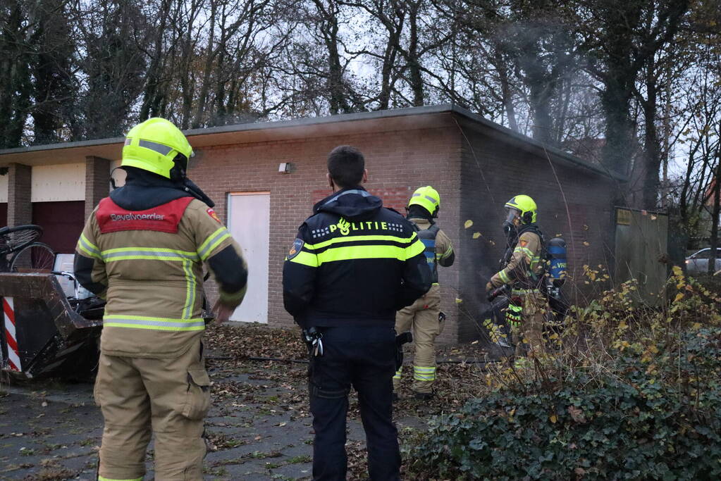 Wasmachine in brand tegen gebouw
