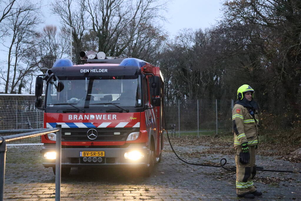 Wasmachine in brand tegen gebouw