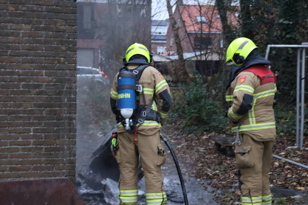 Wasmachine in brand tegen gebouw