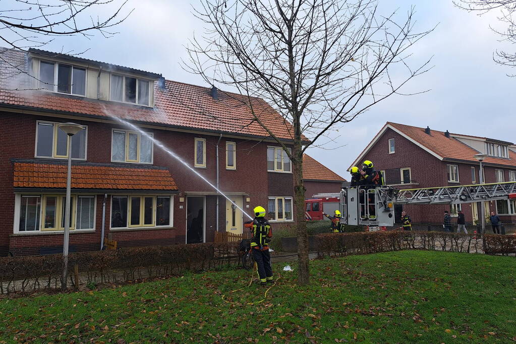 Veel rook uit dakkapel bij woningbrand