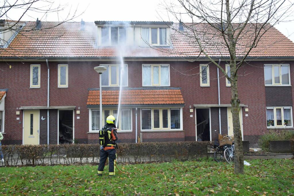 Veel rook uit dakkapel bij woningbrand