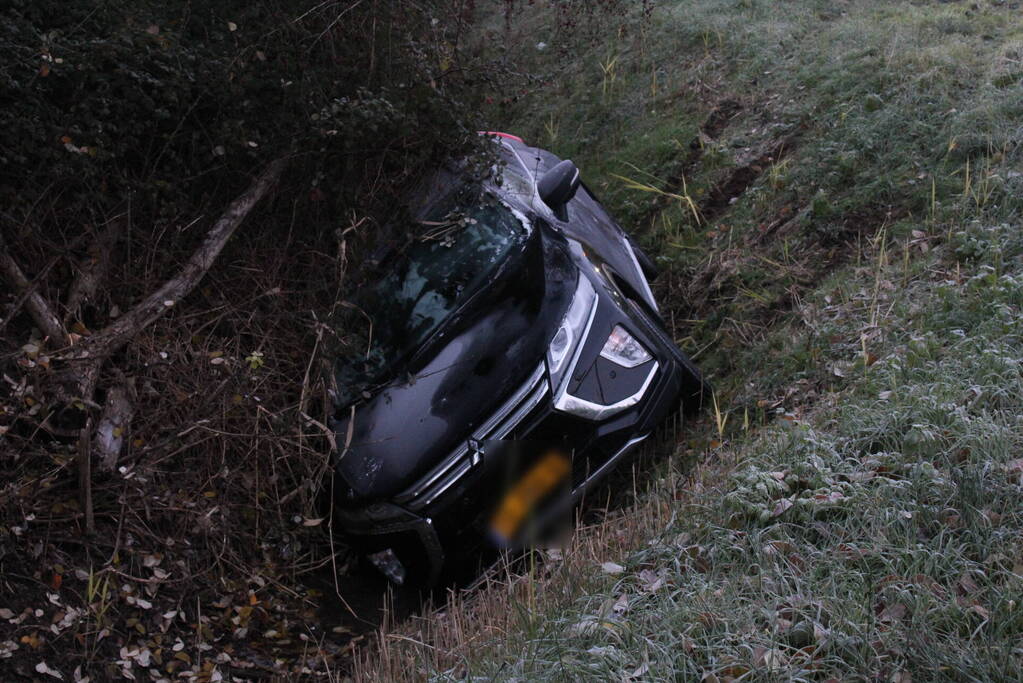 Auto raakt van de weg en belandt half in de sloot