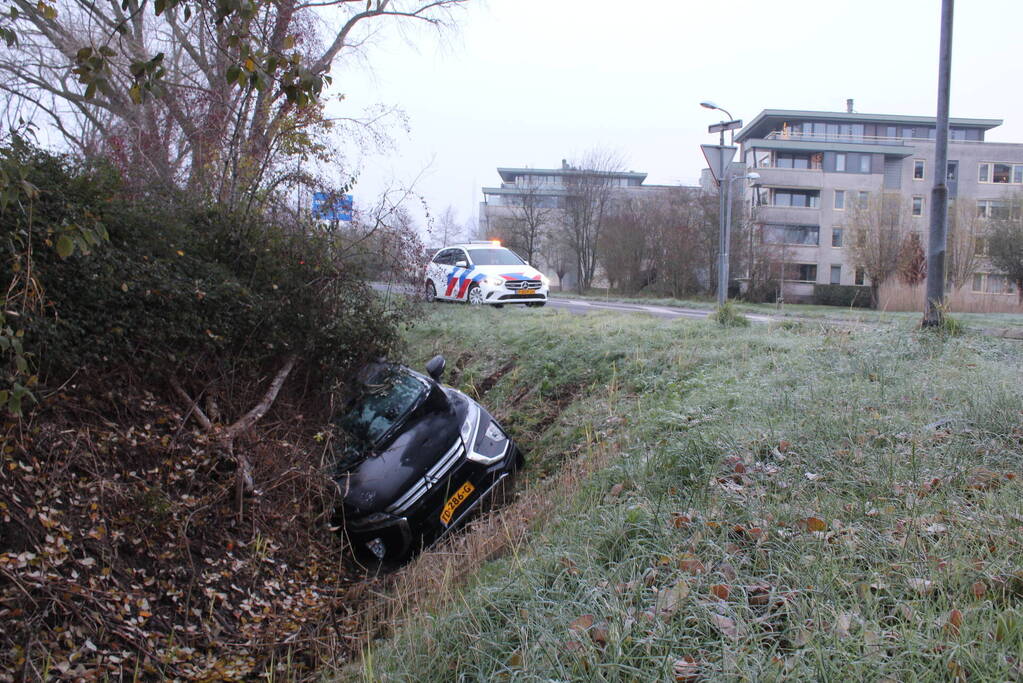 Auto raakt van de weg en belandt half in de sloot
