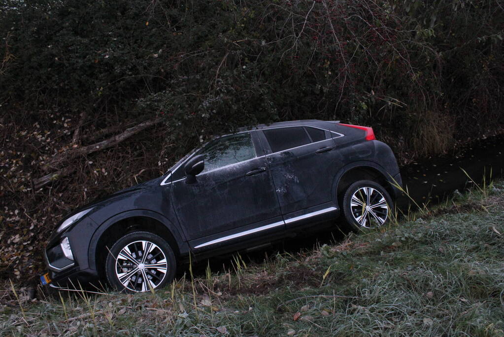 Auto raakt van de weg en belandt half in de sloot