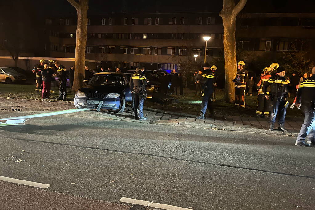 Automobilist ramt lantaarnpaal en elektriciteitskast