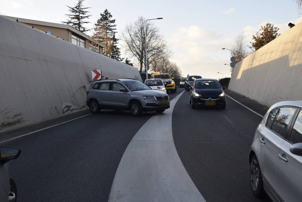 Twee auto's botsen onder spoortunnel