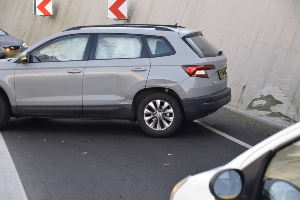 Twee auto's botsen onder spoortunnel