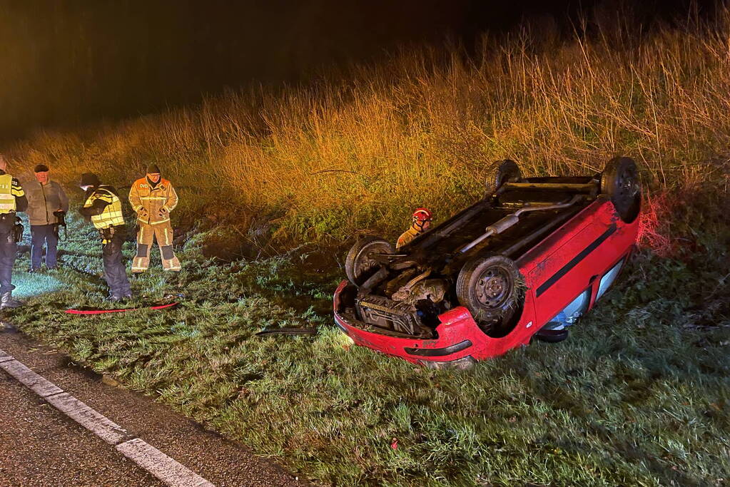 Auto belandt op de kop naast weg