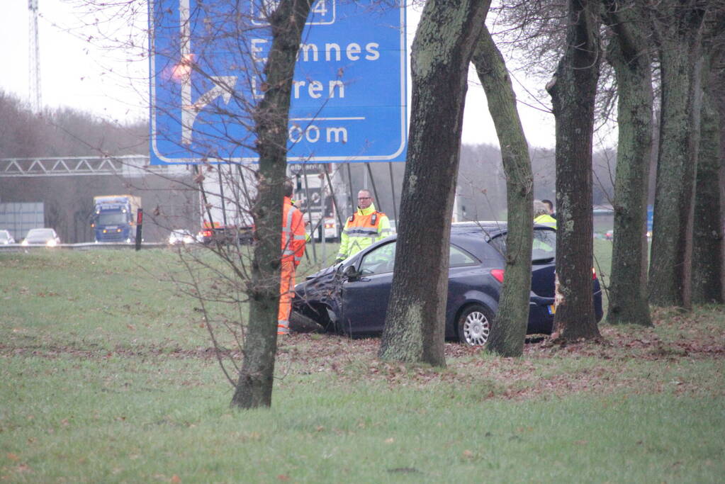 Auto raakt van de snelweg af en knalt tegen boom