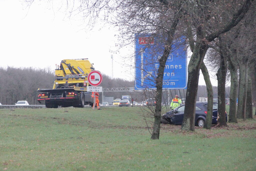 Auto raakt van de snelweg af en knalt tegen boom