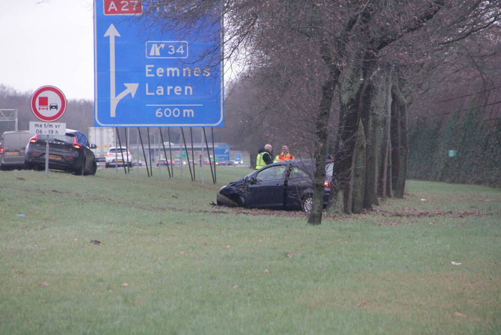 Auto raakt van de snelweg af en knalt tegen boom
