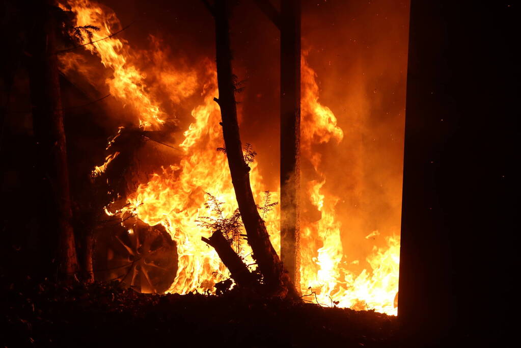 Personenauto vat vlam onder carport