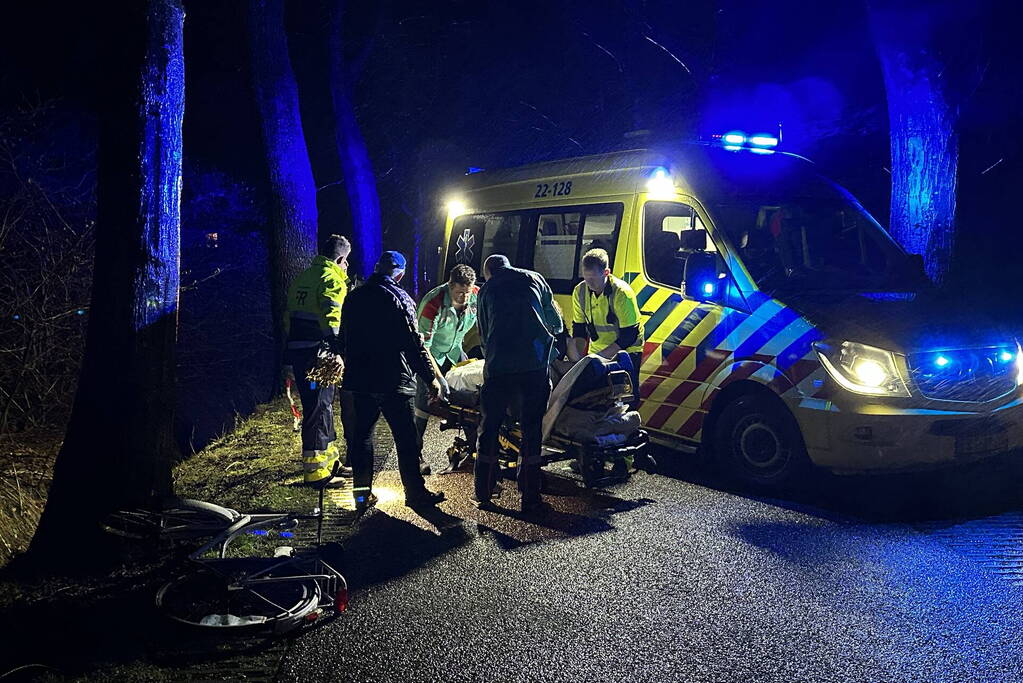 Hulp aan gevallen fietster op donkere weg