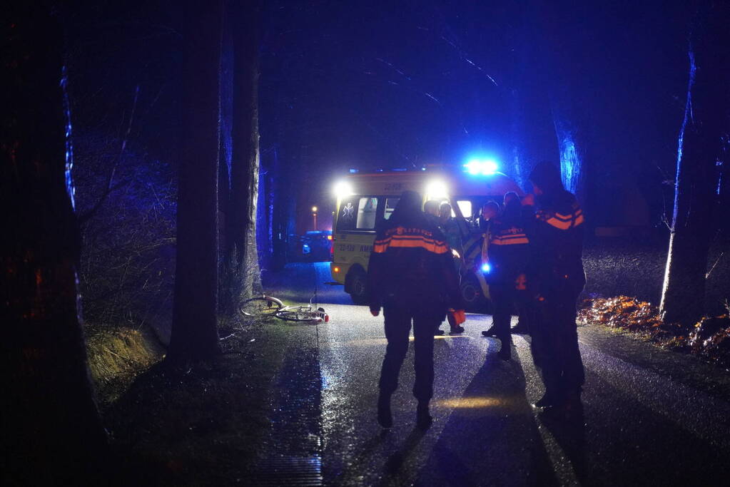Hulp aan gevallen fietster op donkere weg