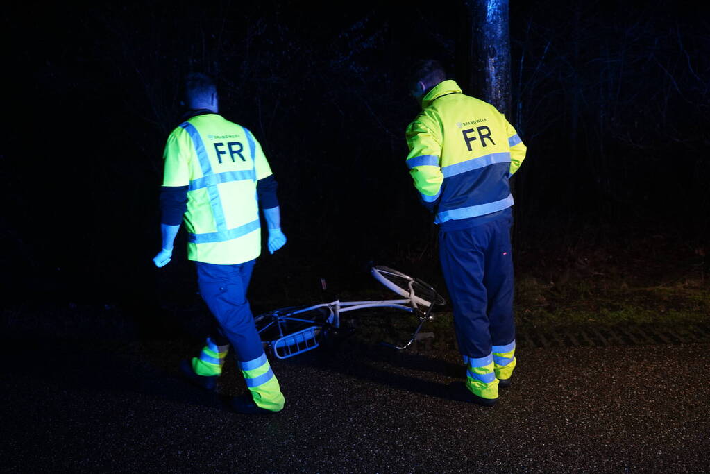 Hulp aan gevallen fietster op donkere weg