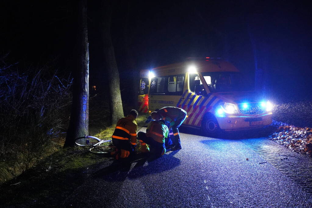 Hulp aan gevallen fietster op donkere weg