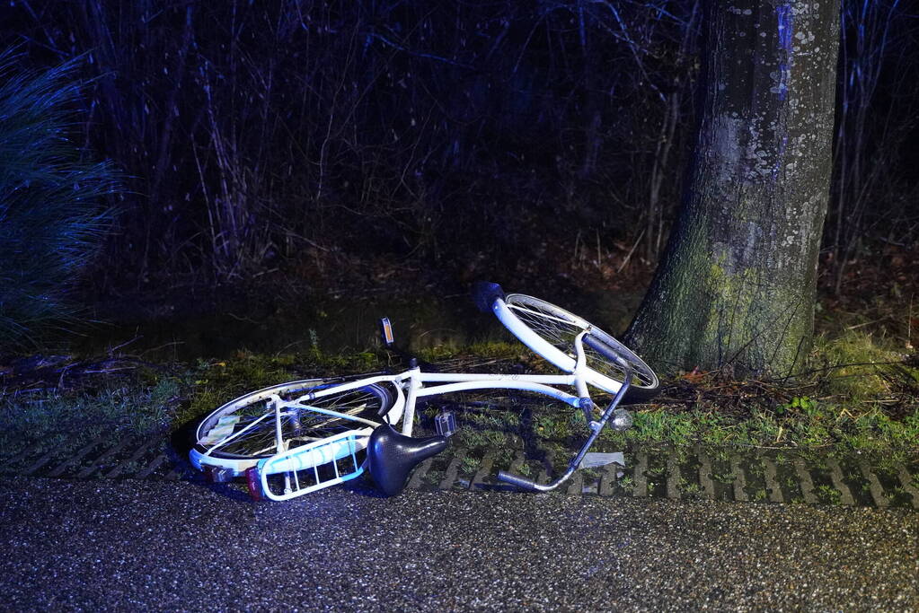 Hulp aan gevallen fietster op donkere weg