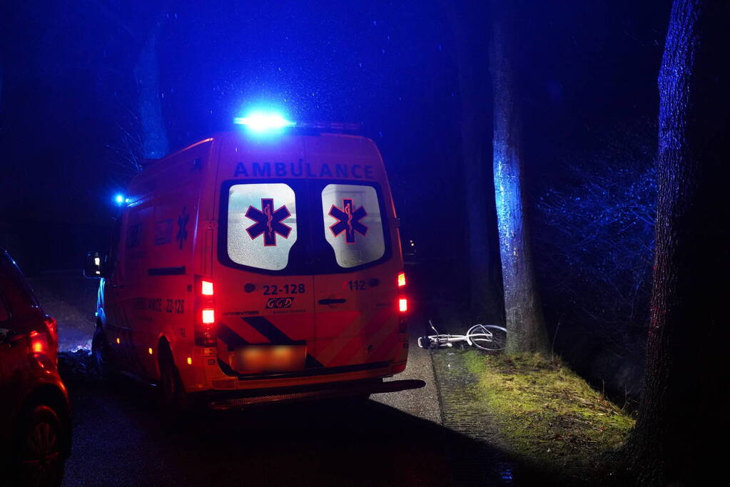 Hulp aan gevallen fietster op donkere weg
