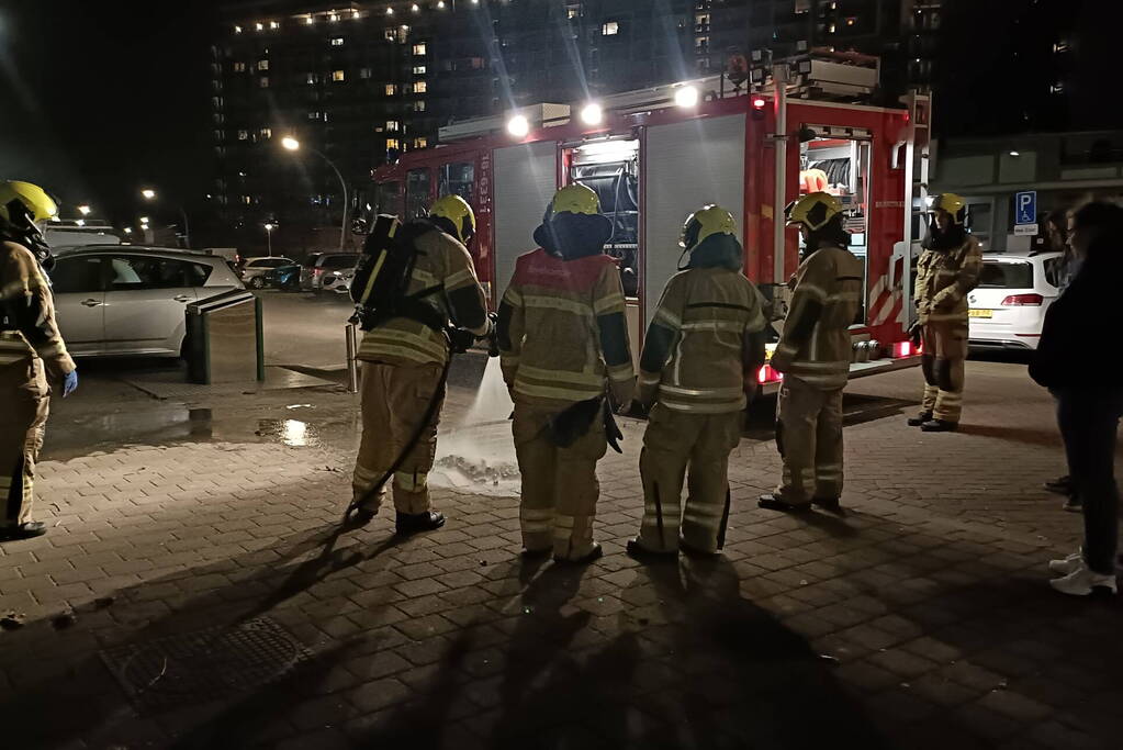 Brandweer blust in brand gestoken container