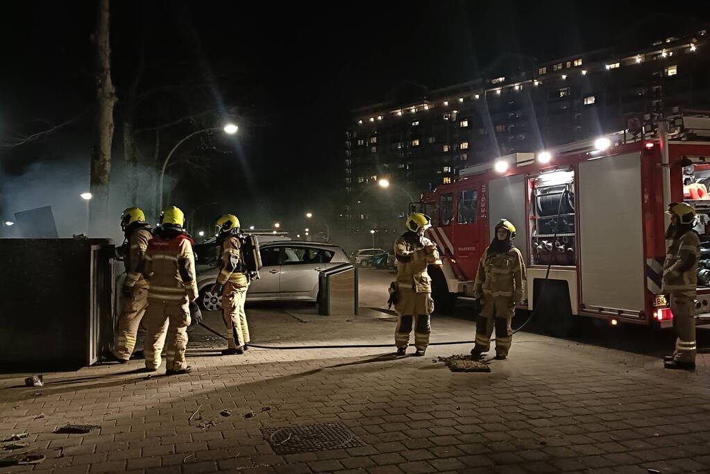 Brandweer blust in brand gestoken container