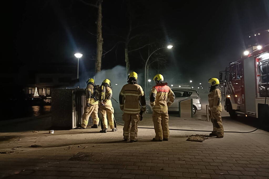 Brandweer blust in brand gestoken container