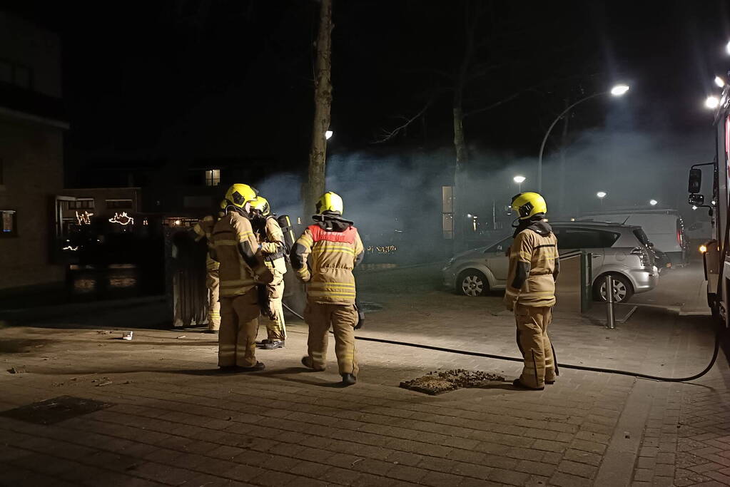 Brandweer blust in brand gestoken container