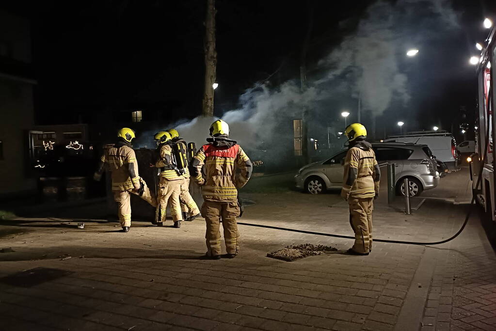 Brandweer blust in brand gestoken container