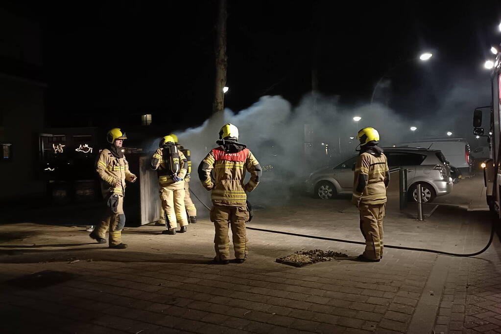 Brandweer blust in brand gestoken container