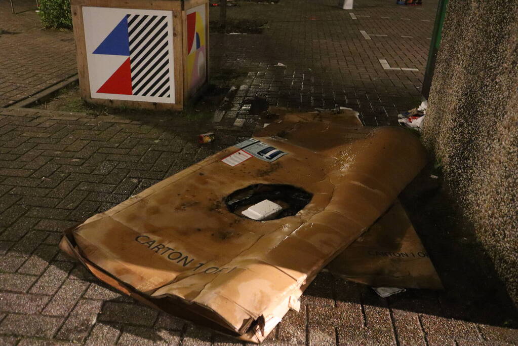 Brandweer blust brandende papiercontainer