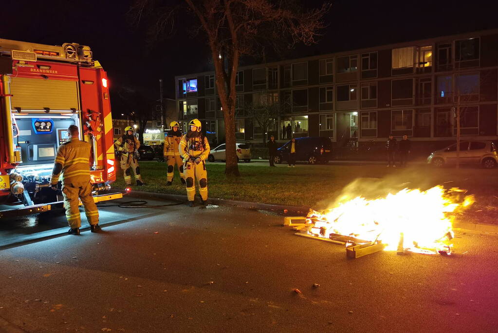 Brandweer blust berg afval op straat