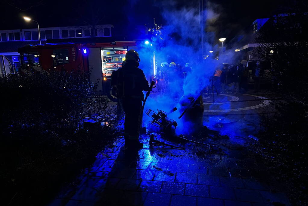 Brandweer blust brandende vuurton en scooter