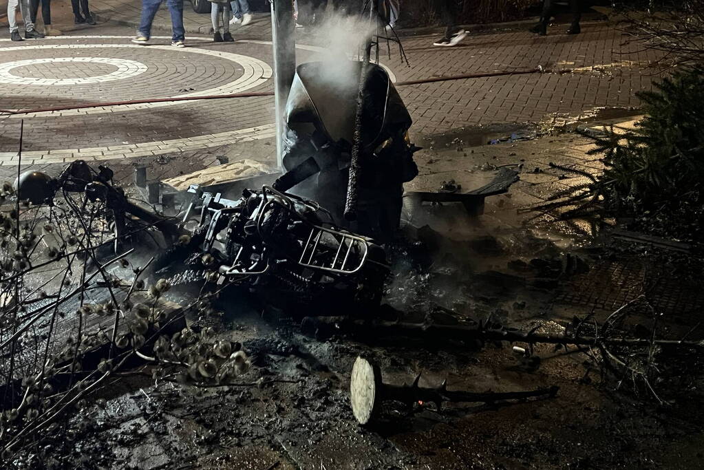 Brandweer blust brandende vuurton en scooter
