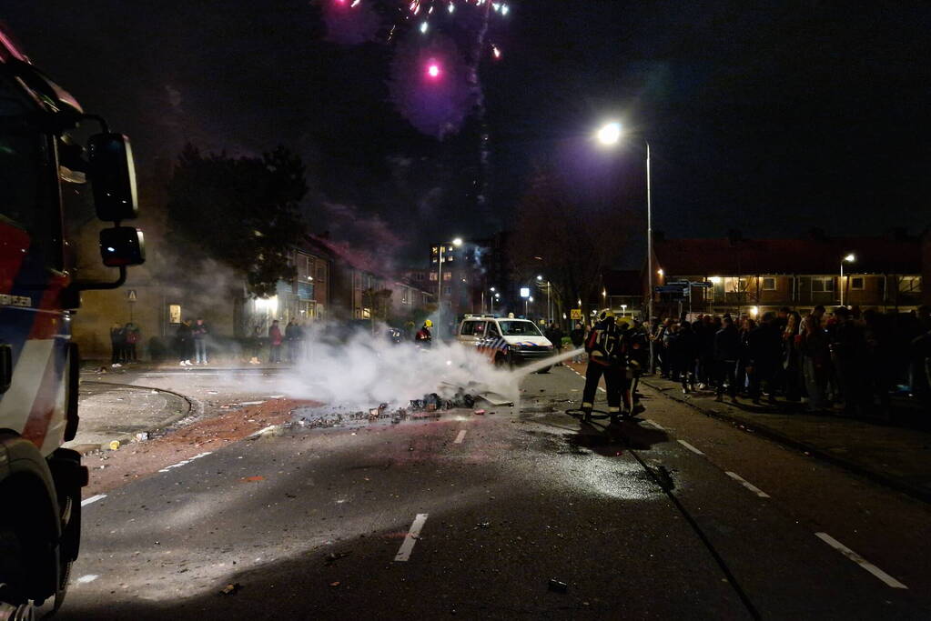 Brandweer blust brandend vuurwerkafval