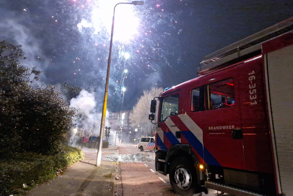 Brandweer blust brandend vuurwerkafval