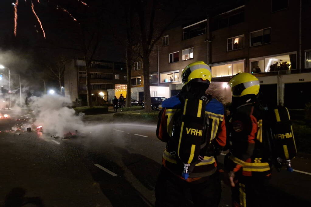 Brandweer blust brandend vuurwerkafval