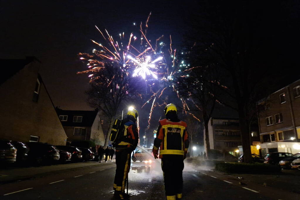 Brandweer blust brandend vuurwerkafval