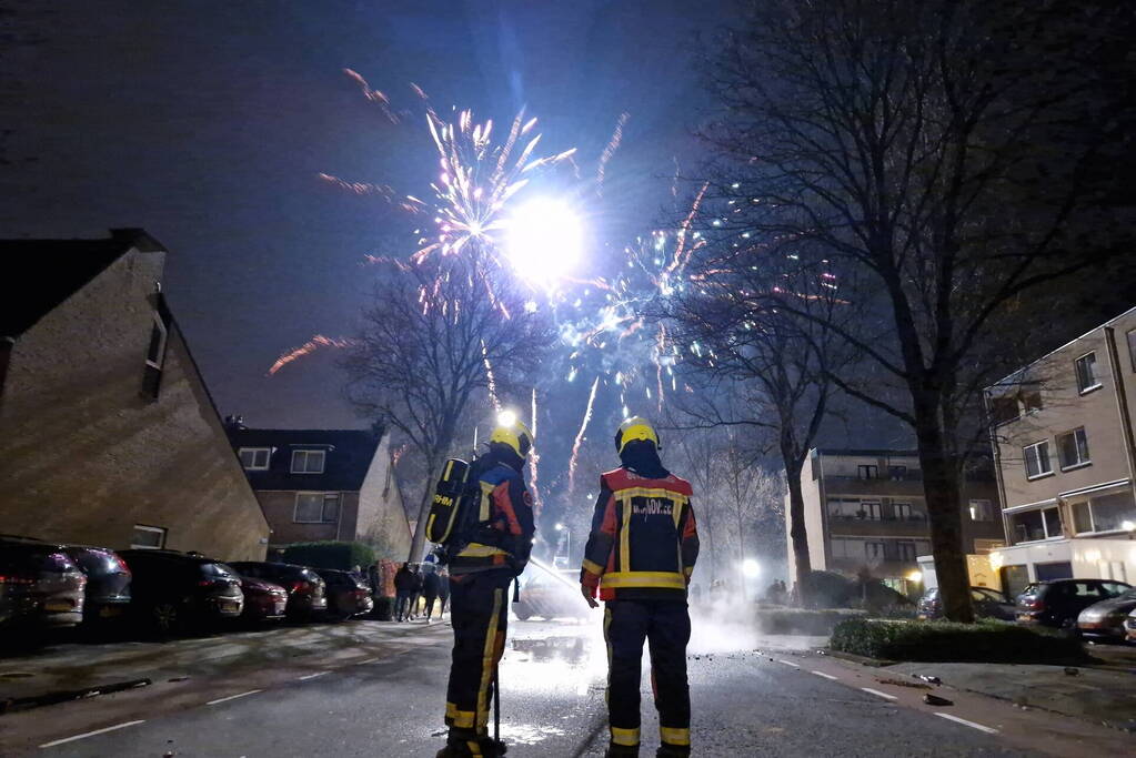 Brandweer blust brandend vuurwerkafval