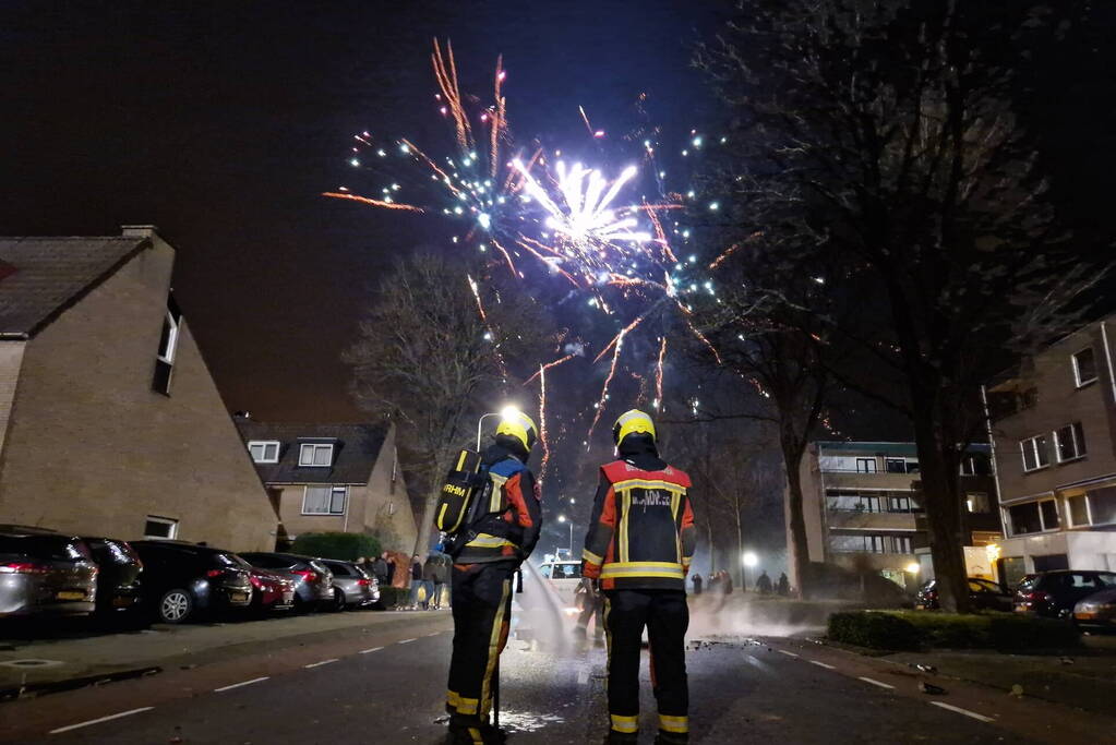 Brandweer blust brandend vuurwerkafval